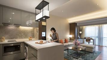 Una cocina moderna con una isla central, electrodomésticos integrados y una zona de comedor con sofá y mesa de centro.