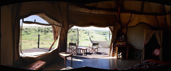 A room with a wooden deck, a table, and chairs. - Amani Mara Camp (Maasai Mara)