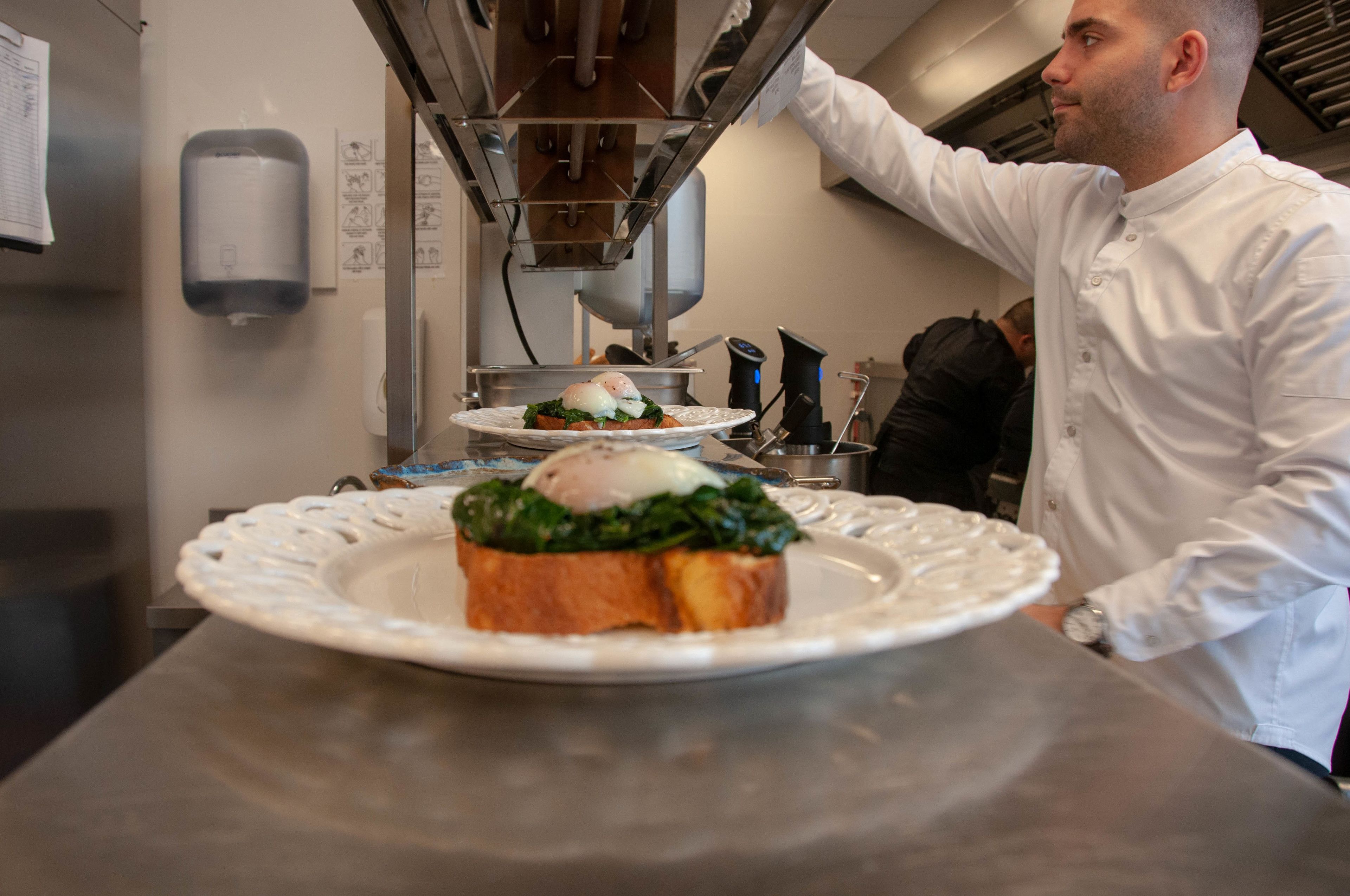 Un chef cuisinier préparant des plats dans une cuisine professionnelle.