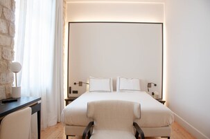 Una habitación de hotel moderna con una cama grande, un escritorio y una silla.