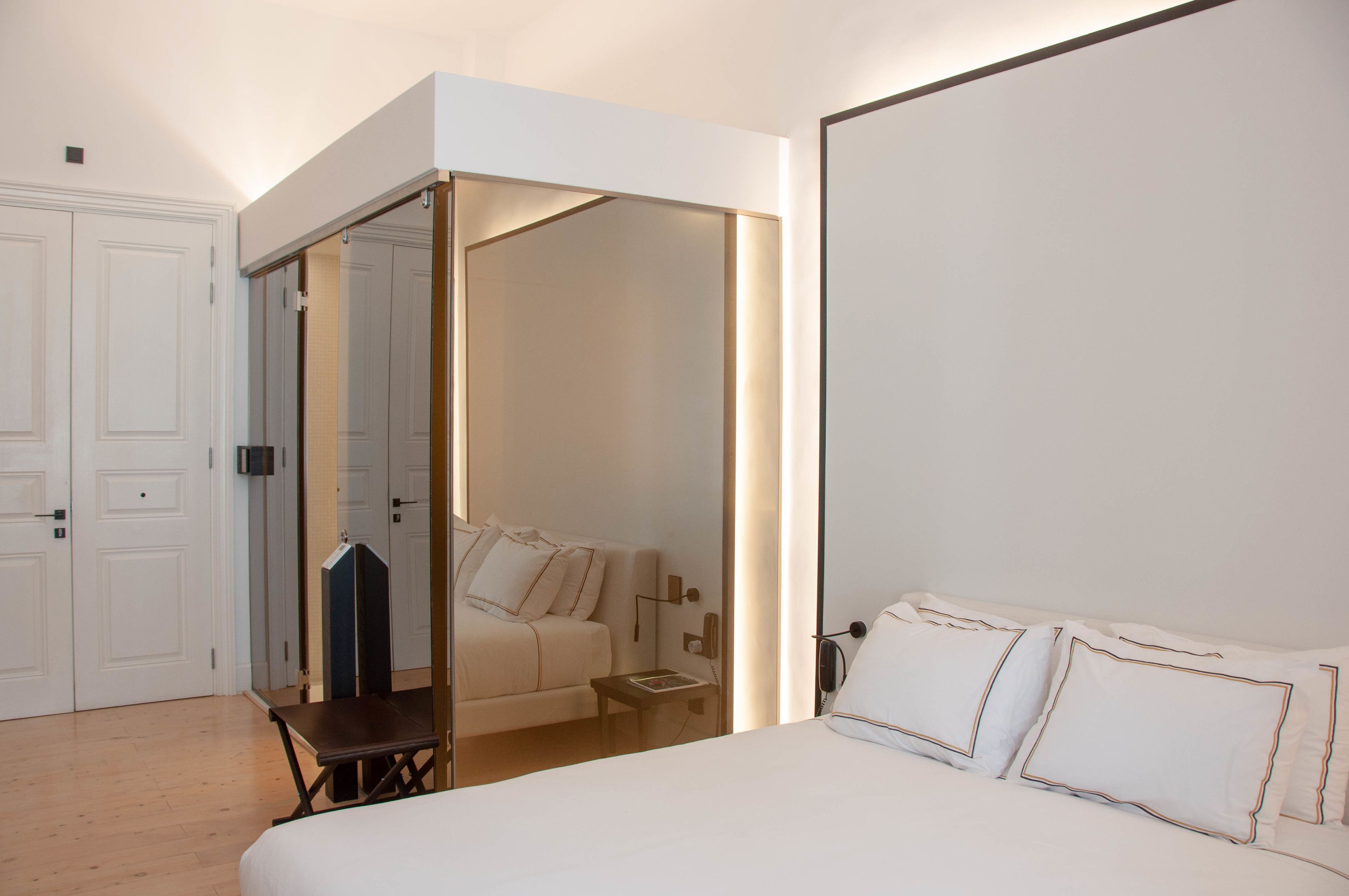 A bedroom with a bed, bedside table, and a wardrobe.