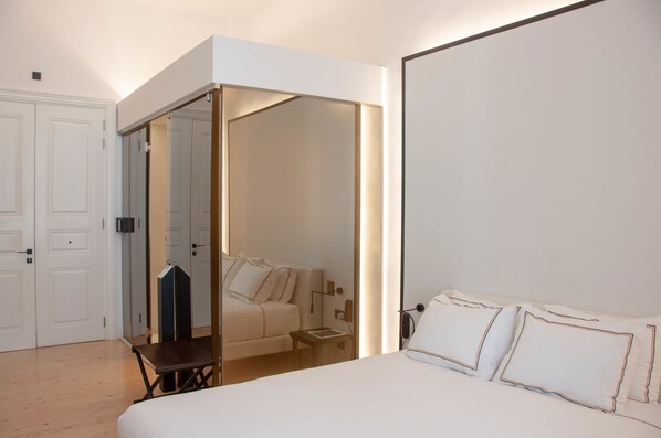 A bedroom with a bed, bedside table, and a wardrobe. - S Paul Hotel (Limassol)