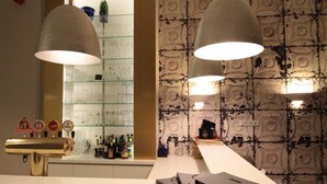 Un espace bar comprenant un comptoir, un miroir et une étagère avec des verres et des bouteilles.
