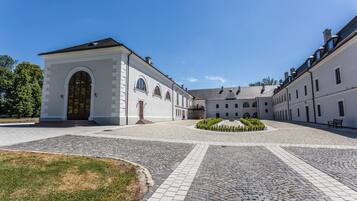 A courtyard with a white building featuring arched windows and a central garden.