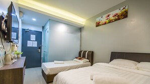 A hotel room with two beds, a desk, a mirror, and a painting on the wall. - U Plus Budget Hotel (Bukit Mertajam)