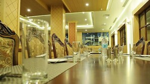 Taula de dinar arrematada amb caires, vas i ampolles d'aigua, que indica una zona de menjador formal en un hotel.