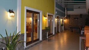 A hotel corridor with glass doors, potted plants, and a staircase. - Apameia Hotel (Mudanya)