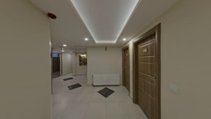 A hallway with a tiled floor, a radiator, and wooden doors. - Apameia Hotel (Mudanya)
