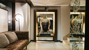 A modern lobby with a sofa, a Buddha statue, and decorative mirrors. - The Royale Senate Hebbal (Bengaluru)