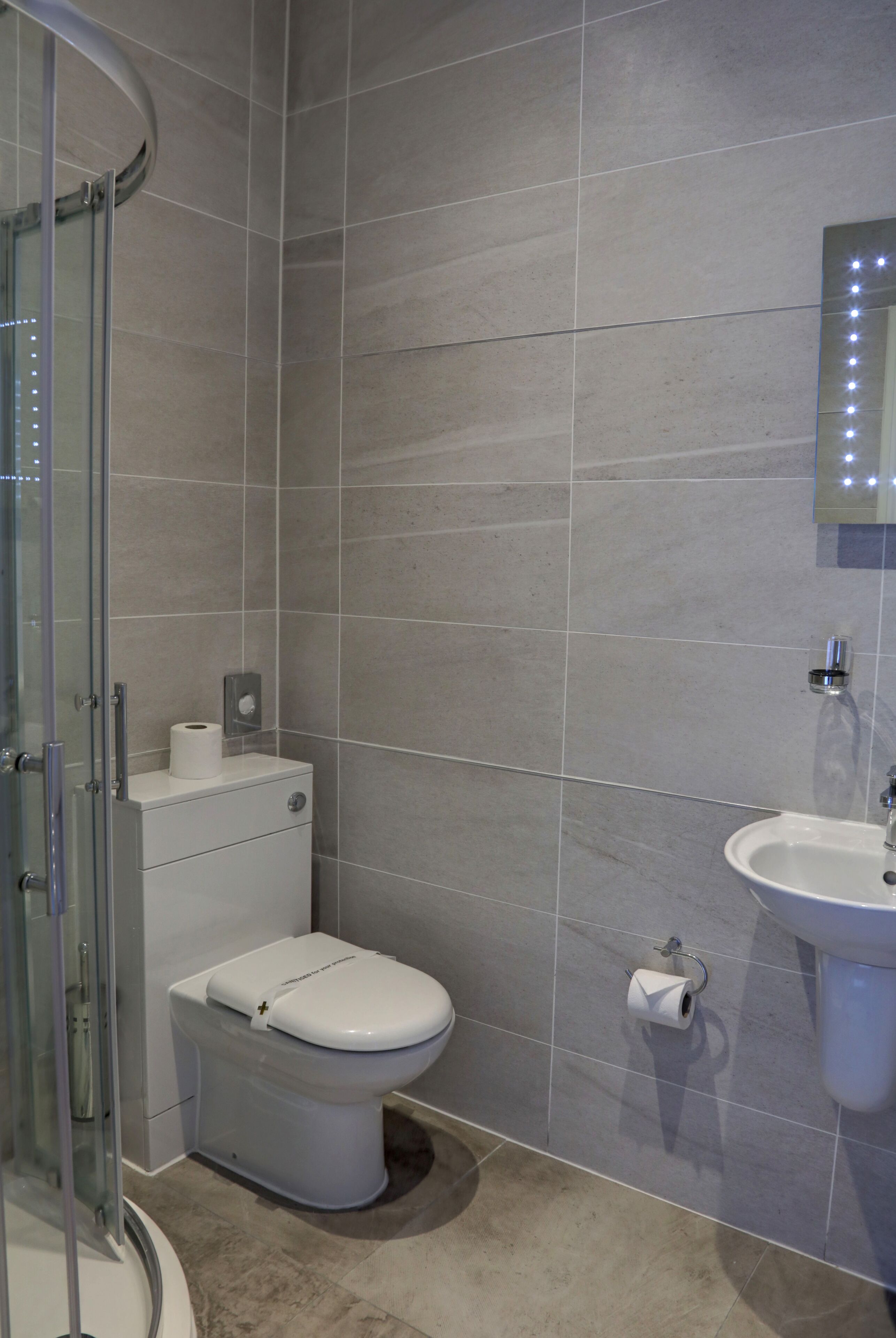 A bathroom with a toilet, sink, and shower.
