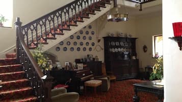 A staircase with a dark railing, a patterned carpet, and a wall adorned with plates.