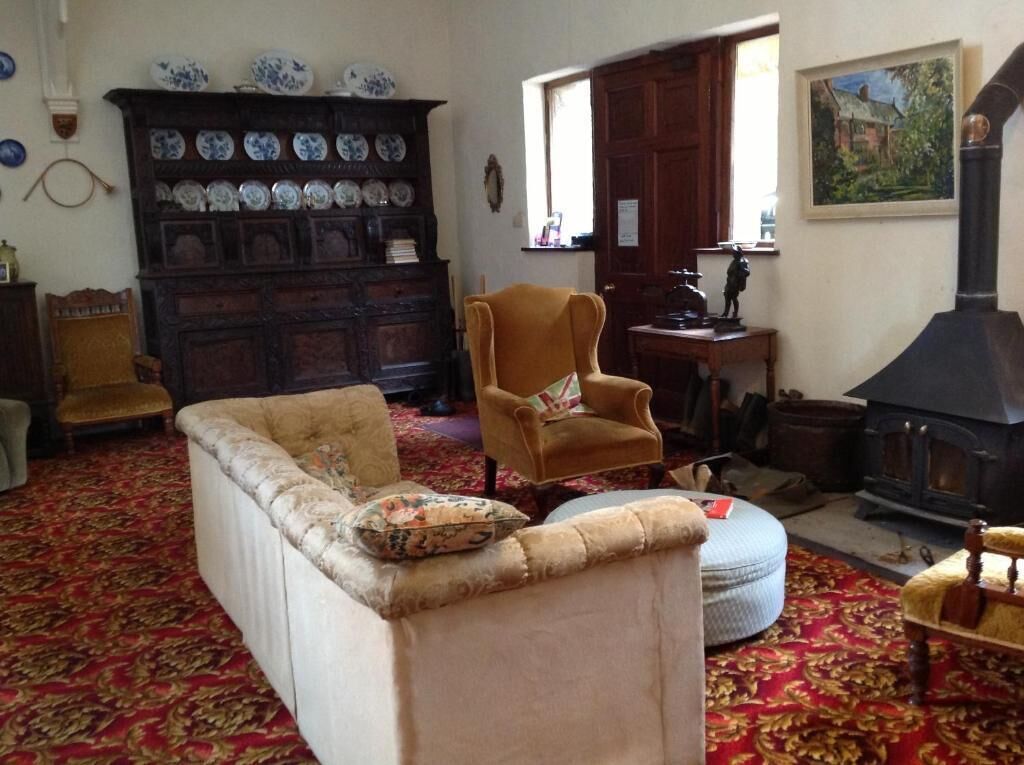 A traditional room with a sofa, armchair, and a fireplace.