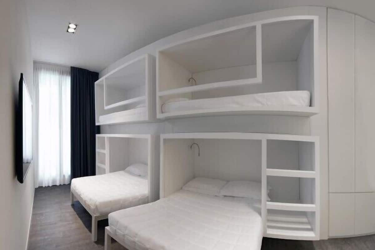 Een kamer met twee stapelbedden, een ligbed en een inbouwkast.