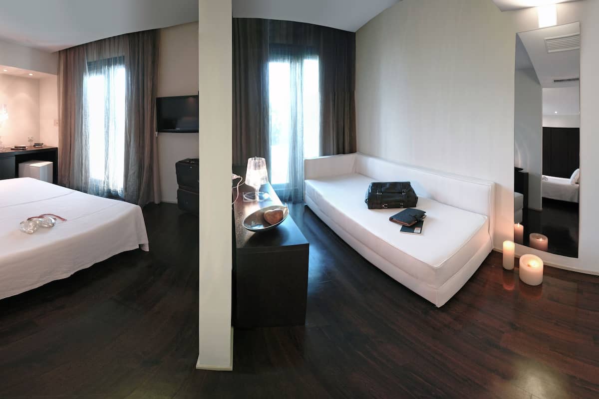 Een moderne hotelkamer met een groot bed, een bureau, een bank en een televisie.