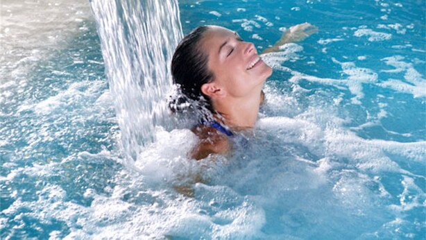 A person in a swimming pool with water flowing from a pipe. - Hotel Europa Monetti (Cattolica)