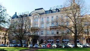Ein historisches Hotel mit einer klassischen Fassade, mehreren Stockwerken und einer markanten Kuppel.