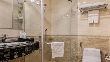 Un bagno moderno con cabina doccia in vetro, lavabo in marmo e toilette.