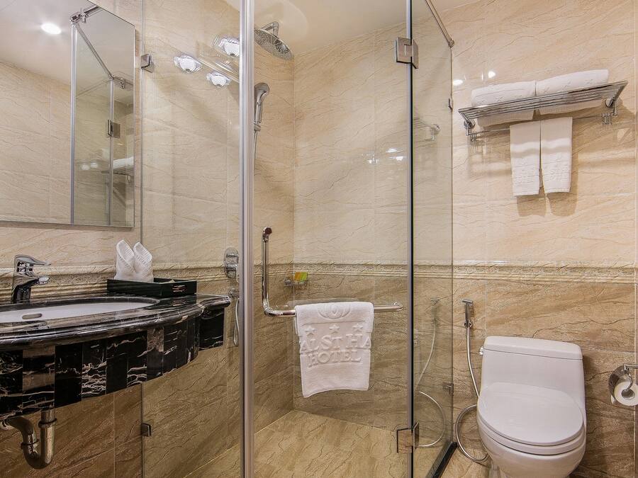 Un bagno moderno con cabina doccia in vetro, lavabo in marmo e toilette.