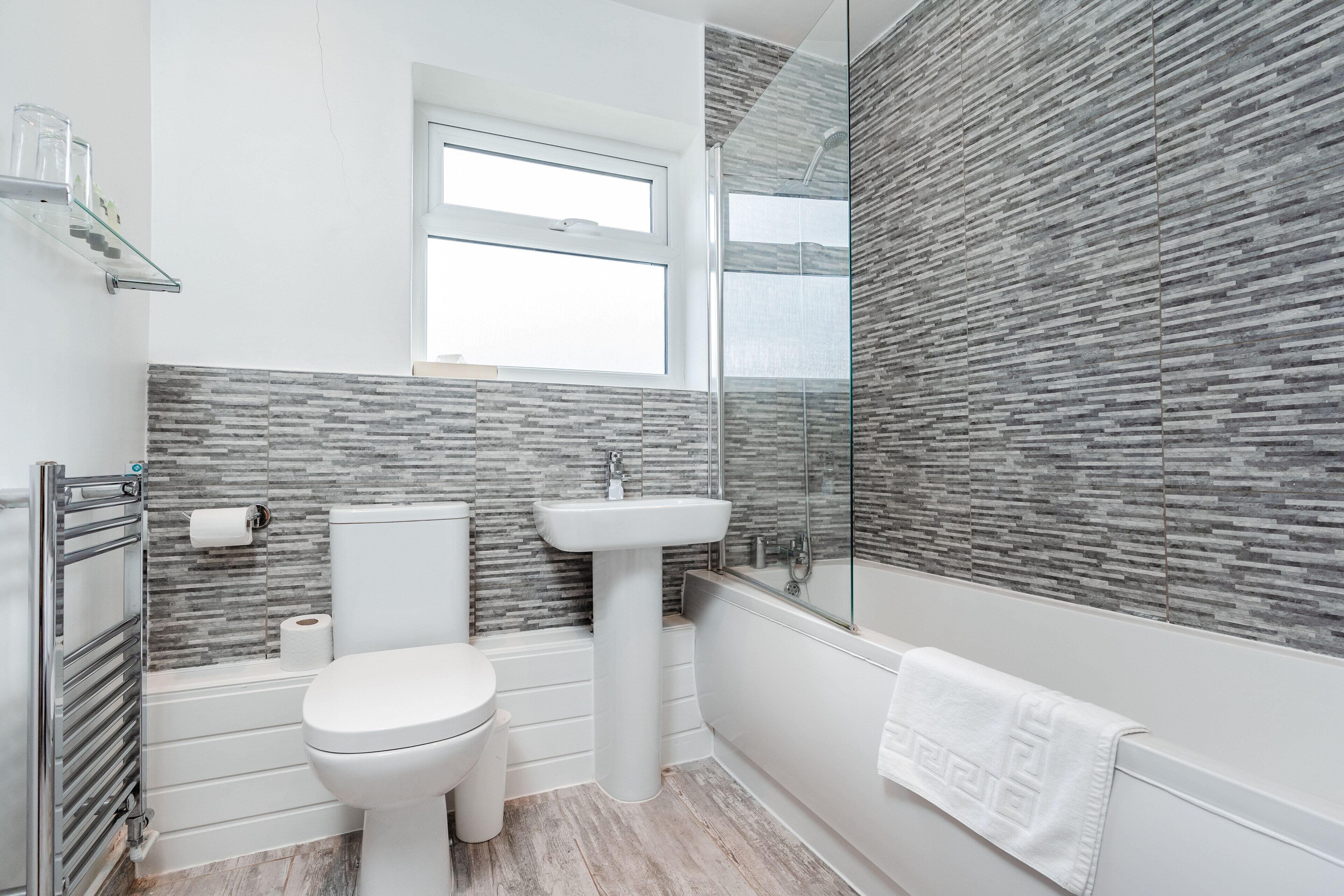 A modern bathroom with a toilet, sink, and shower.