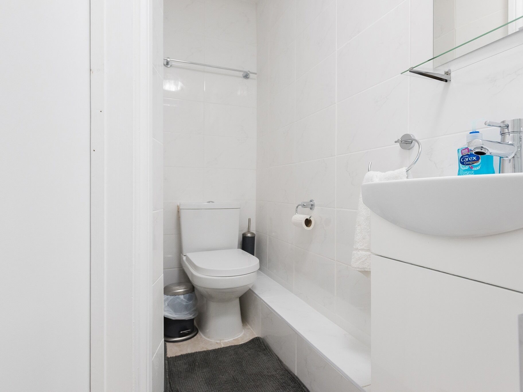 Un baño pequeño y moderno con inodoro, bidé y lavabo.