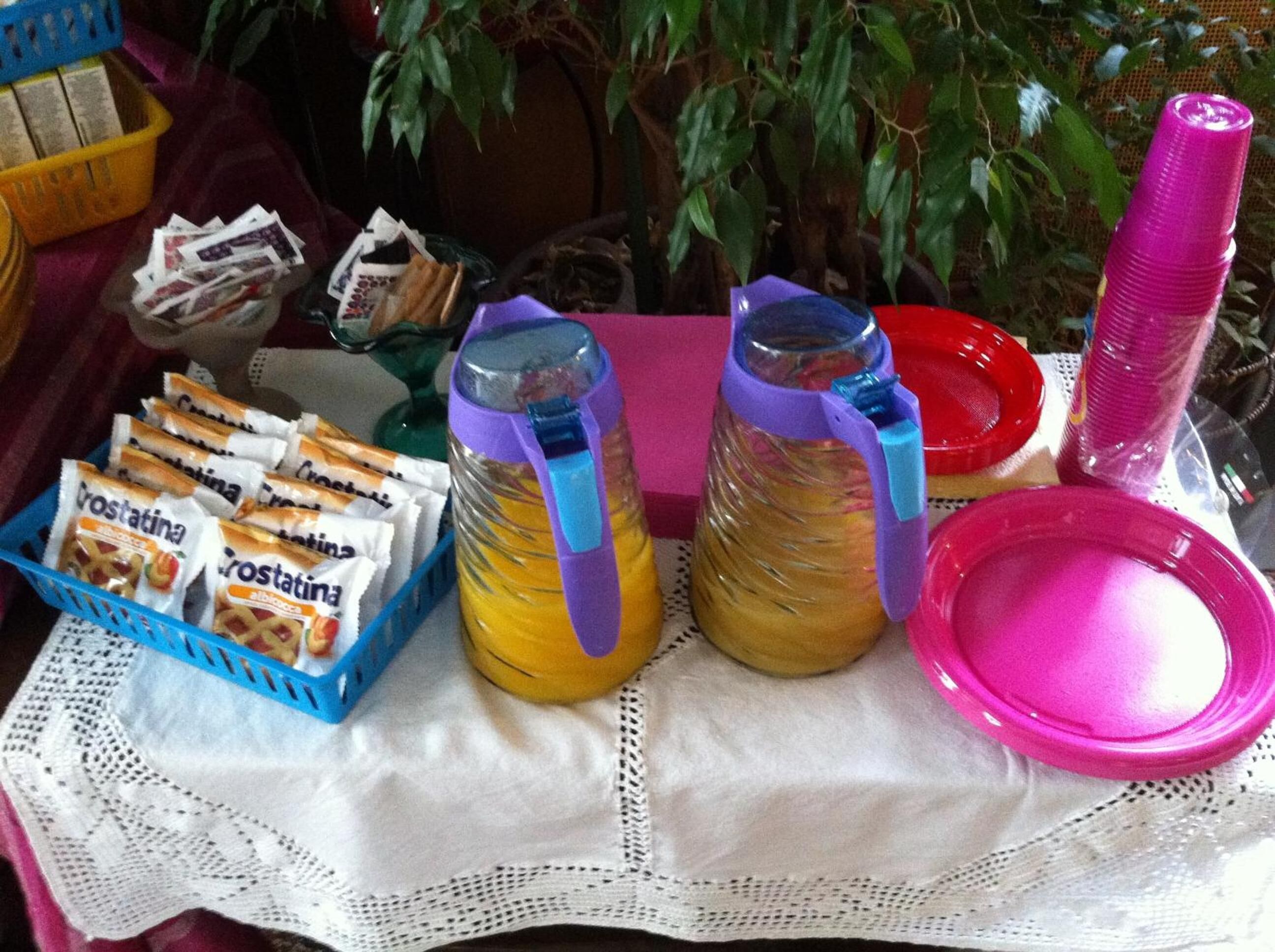 A table with food items, including crostina and albacucca, and two glass bottles with purple handles.