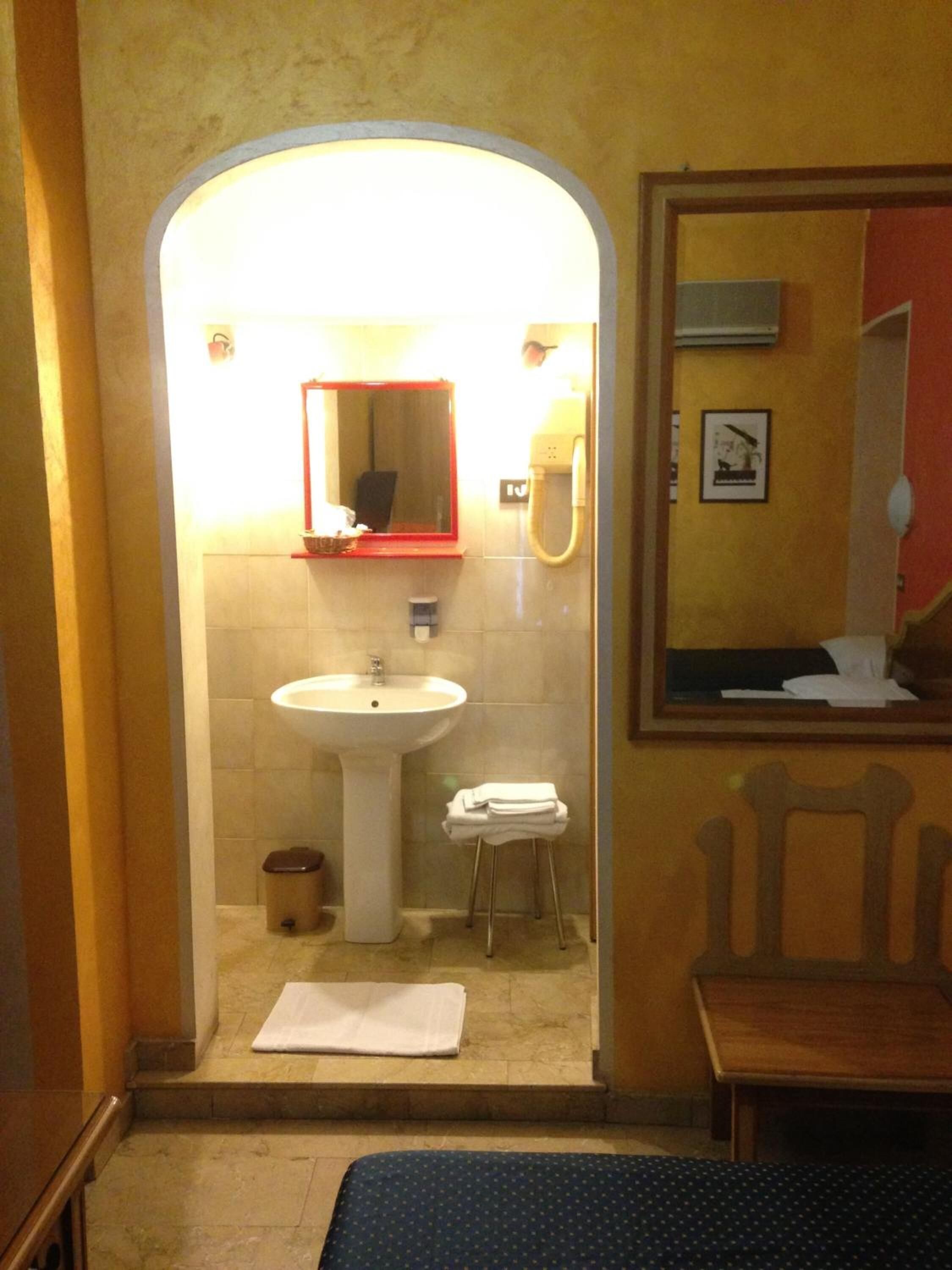 A bathroom with a sink, mirror, and towel rack.
