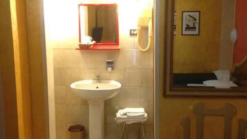 A bathroom with a sink, mirror, and towel rack.