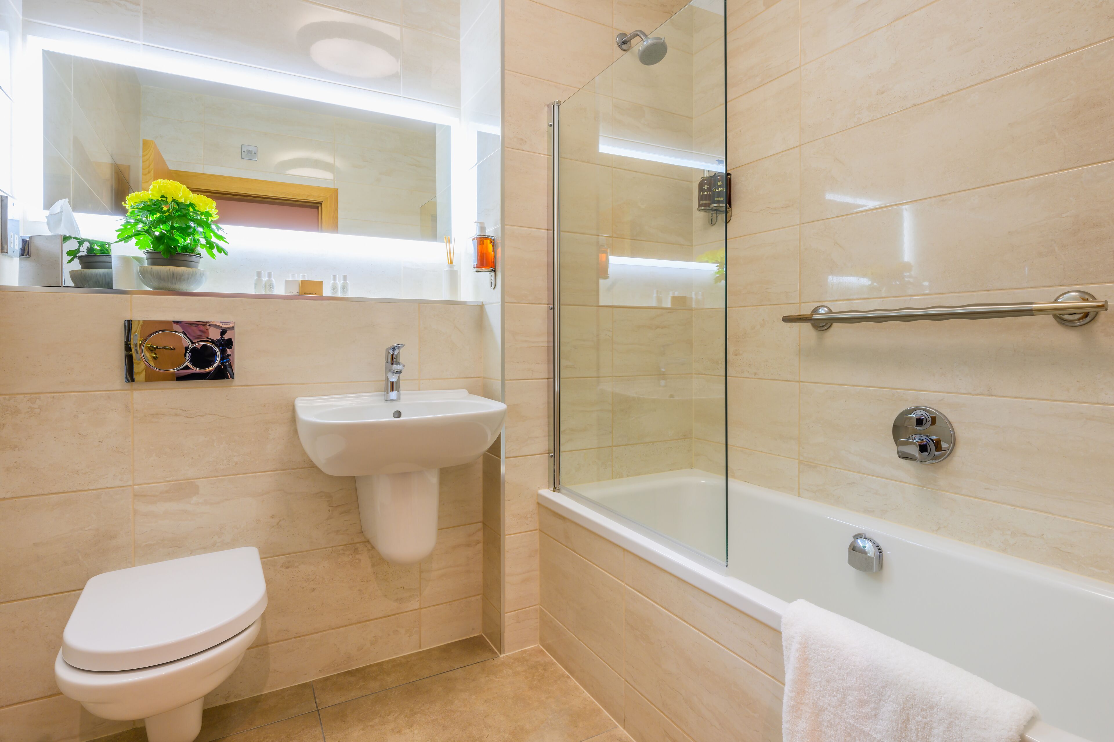 A modern bathroom with a toilet, sink, and glass-enclosed shower.