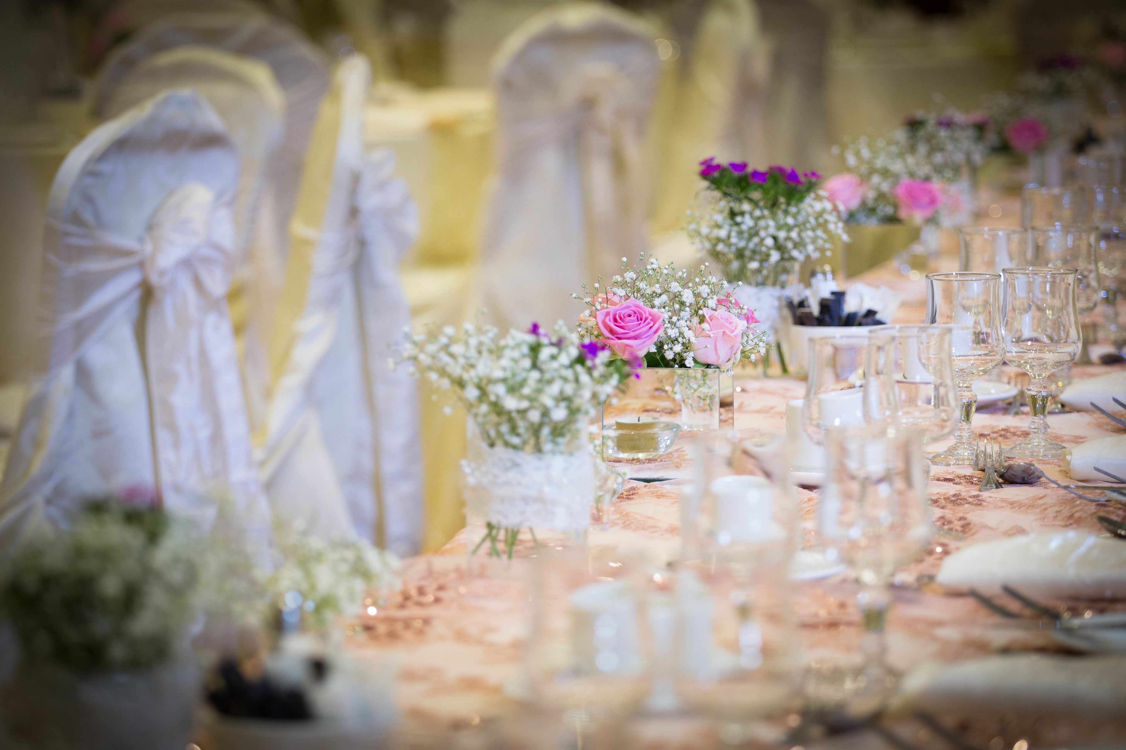 A table set for a formal event with glassware and floral centerpieces.
