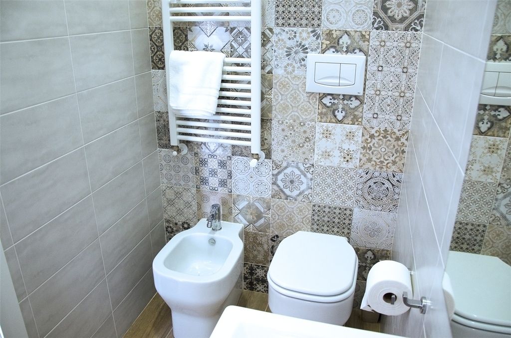 Un baño con bidé, inodoro y un perchero para toallas.