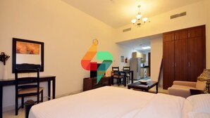 Ein Hotelzimmer mit Bett, Schreibtisch, Stuhl, Essbereich und Kleiderschrank.
