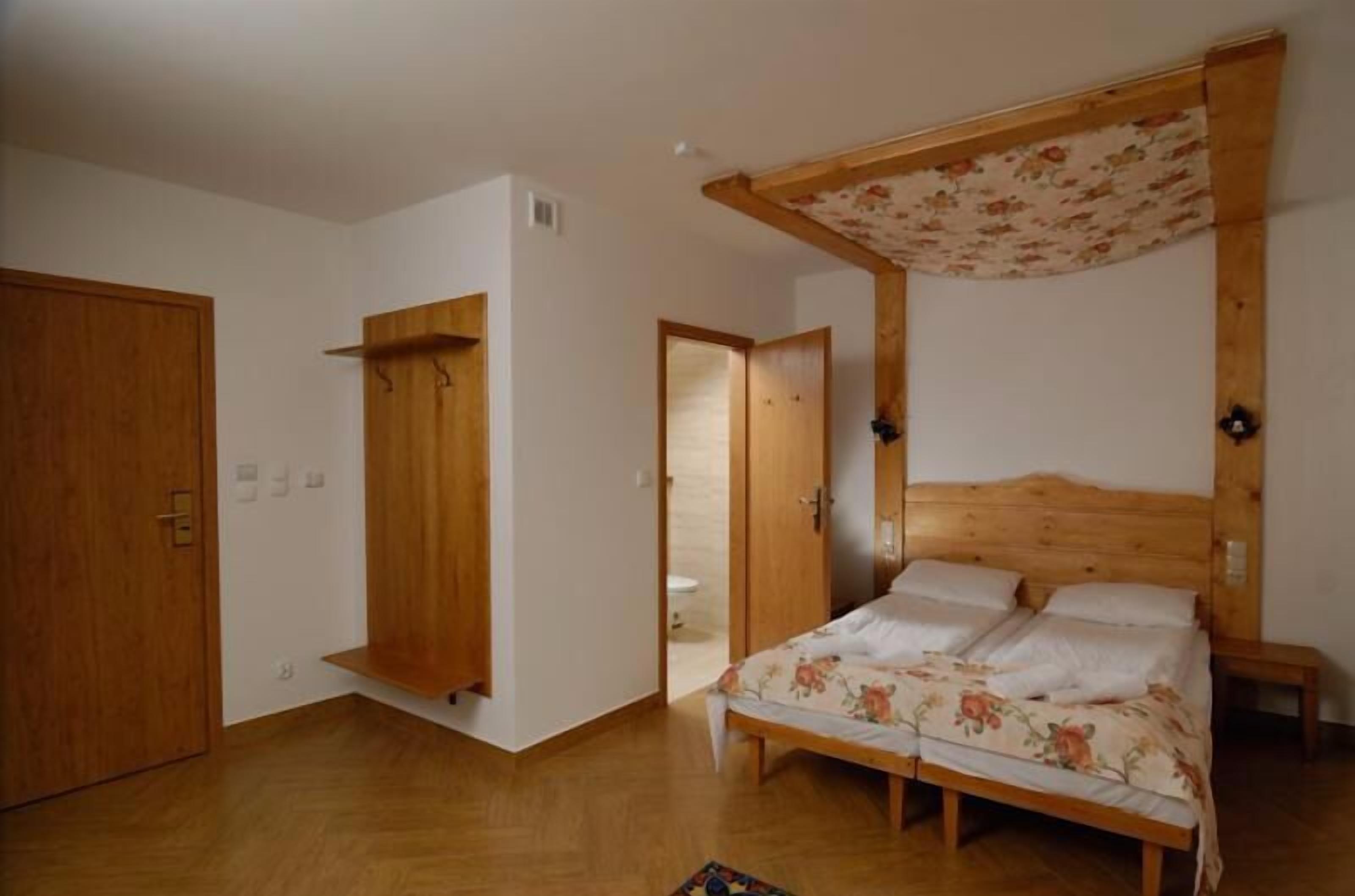 A bedroom with a wooden bed, a wooden wardrobe, and a wooden door.