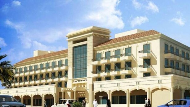 A hotel with a central tower, multiple balconies, and a covered walkway.