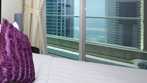 Ein Hotelzimmer mit einem großen Fenster und Blick auf hohe Gebäude.