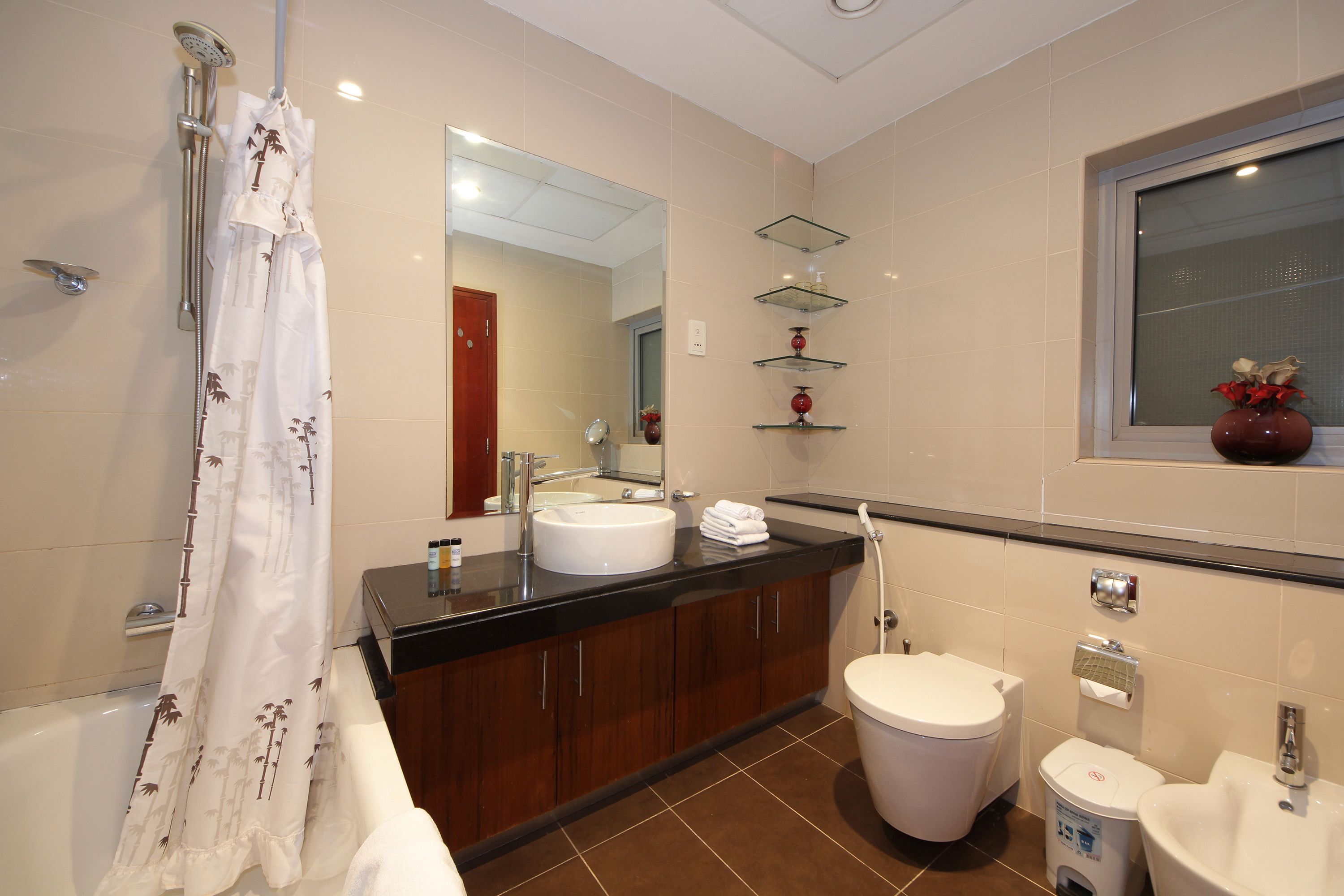 Un baño moderno con bañera, lavamanos, inodoro y tocador.