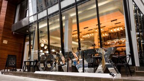 A modern cafe with large glass windows, a wooden facade, and a prominent metal sculpture. - The Connex Asoke (Bangkok)