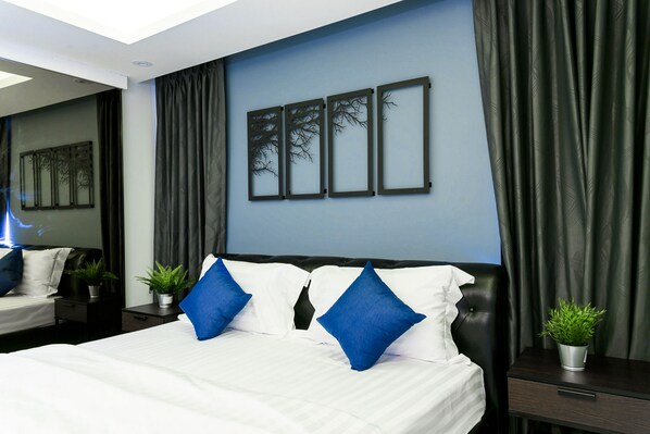 Habitación de hotel moderna con una cama grande, cortinas oscuras y una obra de arte colgada en la pared.