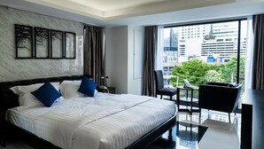 A modern hotel room with a large bed, a dining area, and a view of the city. - The Connex Asoke (Bangkok)