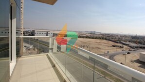 A balcony with a clear view of a road and distant buildings. - Piks Key - Mayfair Residency (Dubai)