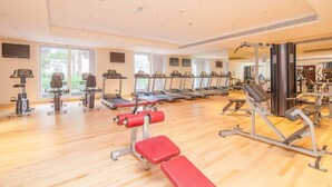 A gym with treadmills, stationary bikes, and weight machines. - Piks Key - Grandeur Residences (Dubai)