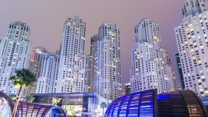 A cityscape with tall, modern buildings and a distinctive dome-shaped structure in the foreground. - Piks Key - Bahar 1 (Dubai)