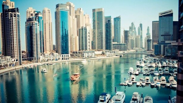 A marina with numerous boats docked, surrounded by high-rise buildings. - Piks Key- Marina Pinnacle (Dubai)