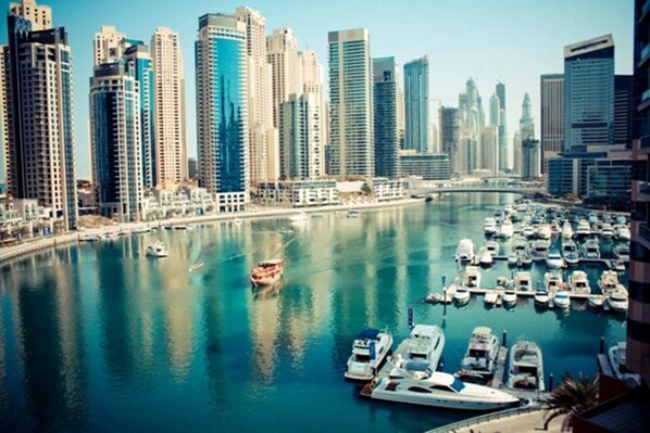 Boats bob gently in the marina, surrounded by sleek city skyscrapers.