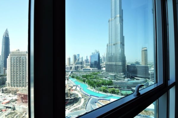 A view of a cityscape with modern skyscrapers, including a prominent tower, through a window.