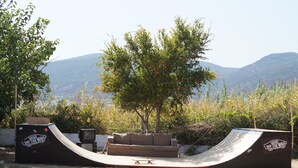 Un parc à skate avec une rampe, un canapé et un arbre.