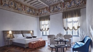 A hotel room with a large bed, two armchairs, a small table, and a blue sofa. - Vistaterra (Parella)