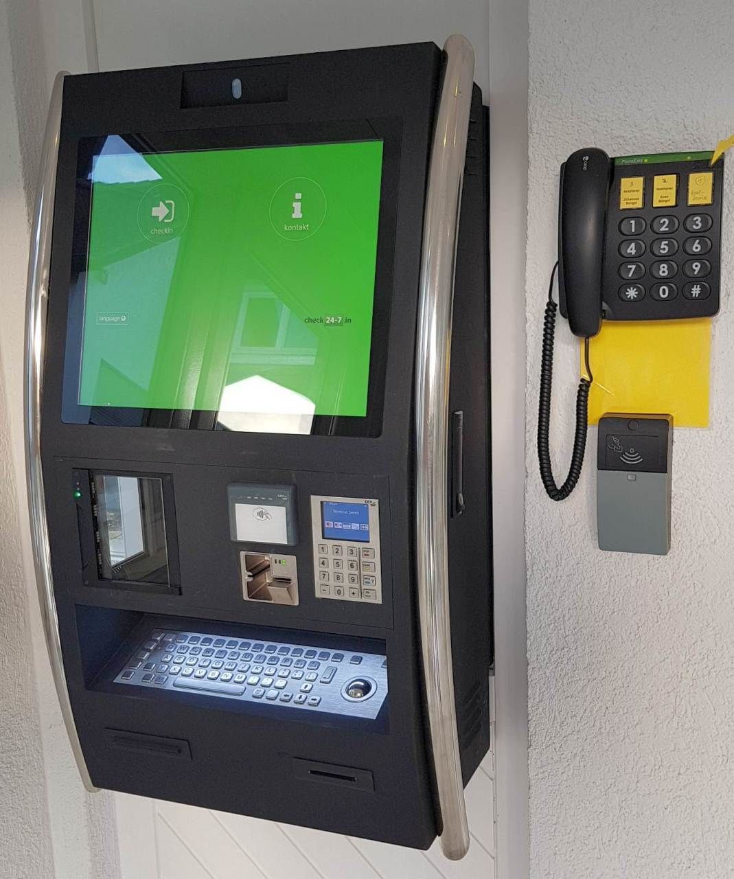 A self-service kiosk with a touchscreen interface, a keypad, and a card reader.