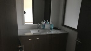 A bathroom with a sink, mirror, and cabinets. - Condominio Costa Pucon (Pucón)