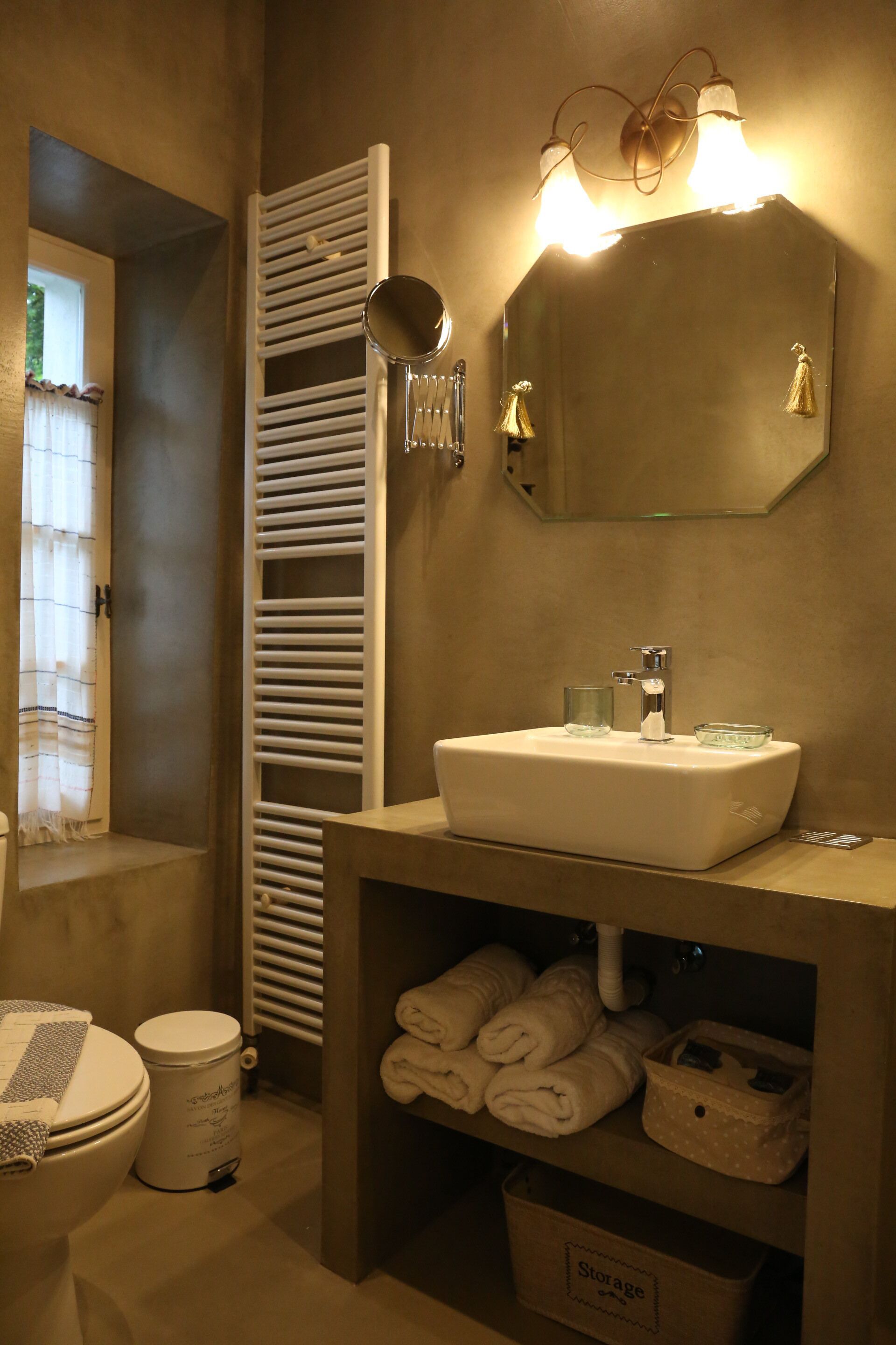 A bathroom with a white sink, a mirror, and a towel rack.