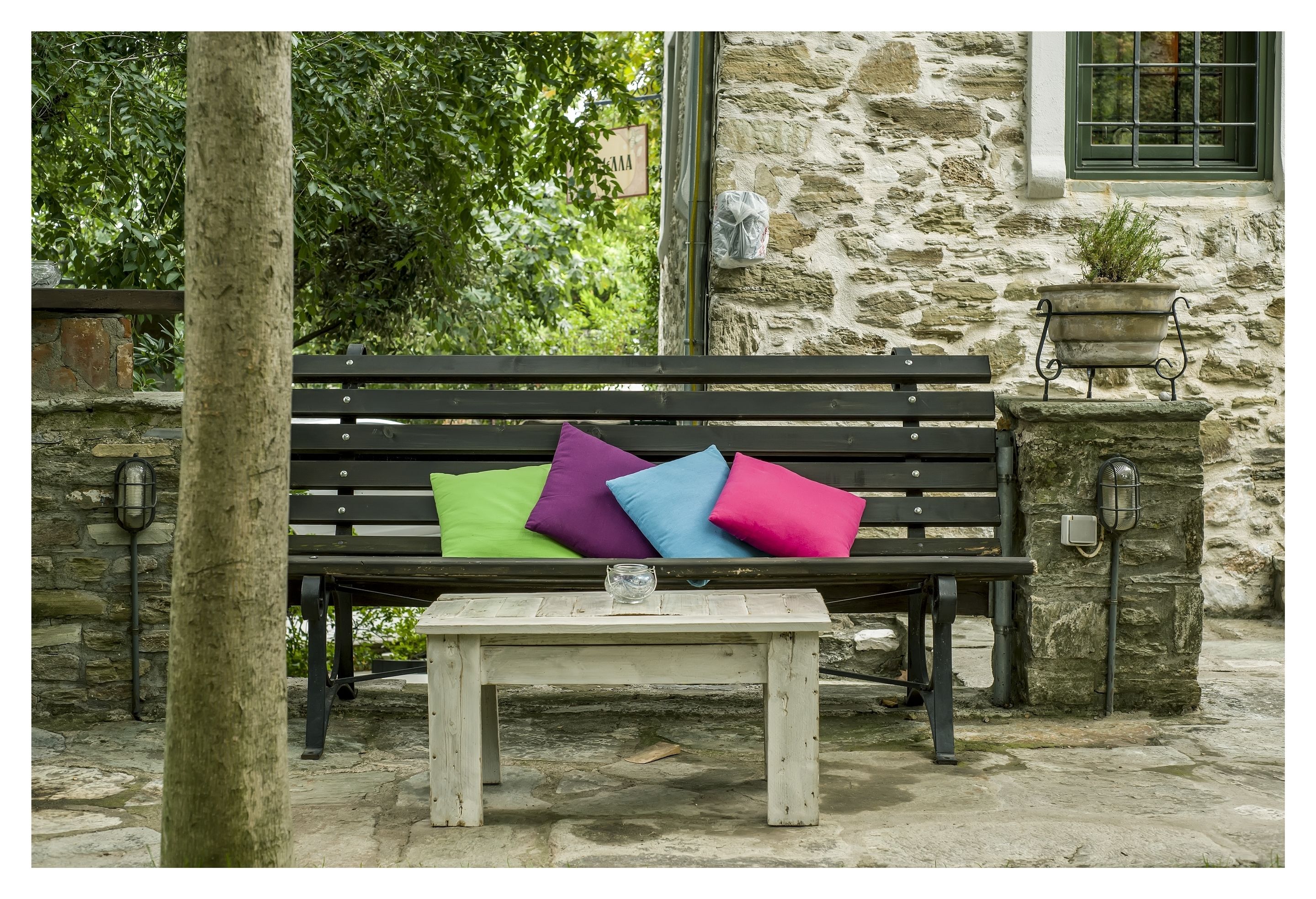 A stone building with a bench and a table.